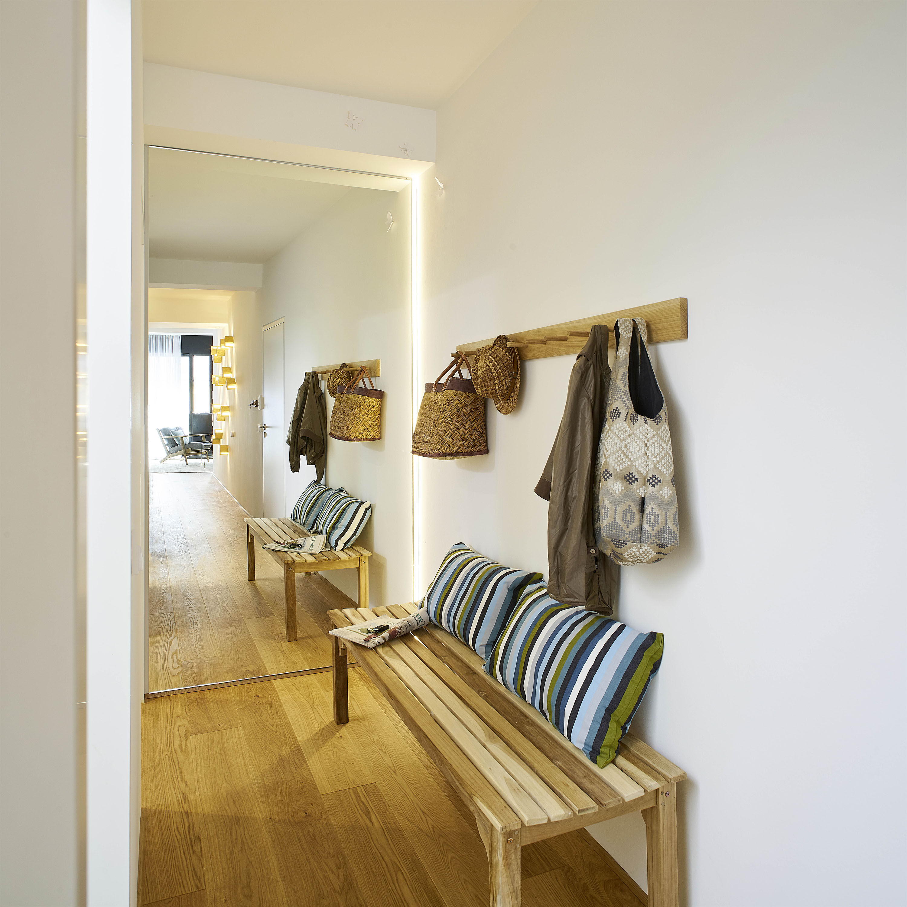 Apartment 8 — hallway with mirror and striped bench cushions