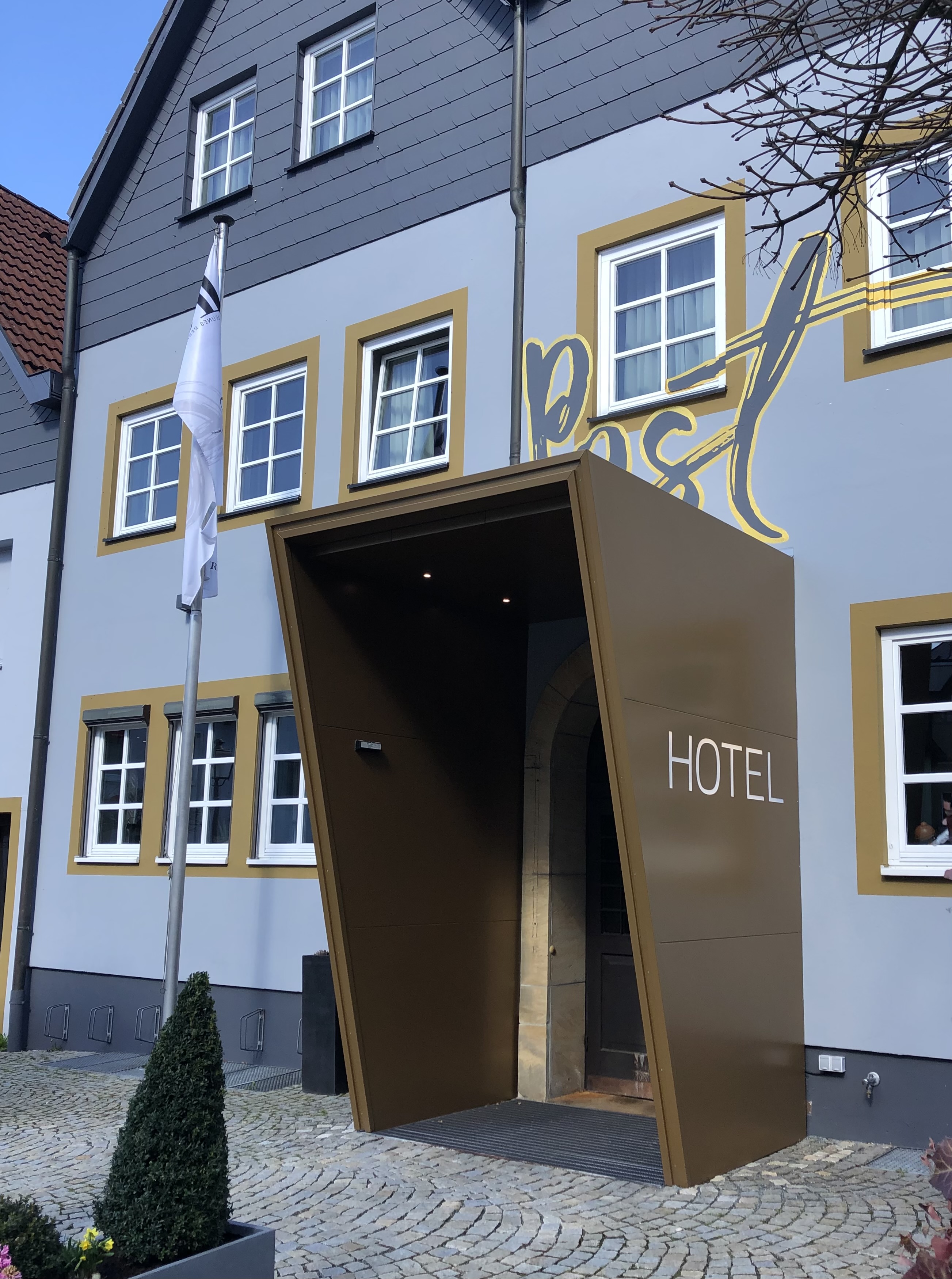 Hotel entrance after — angled bronze canopy