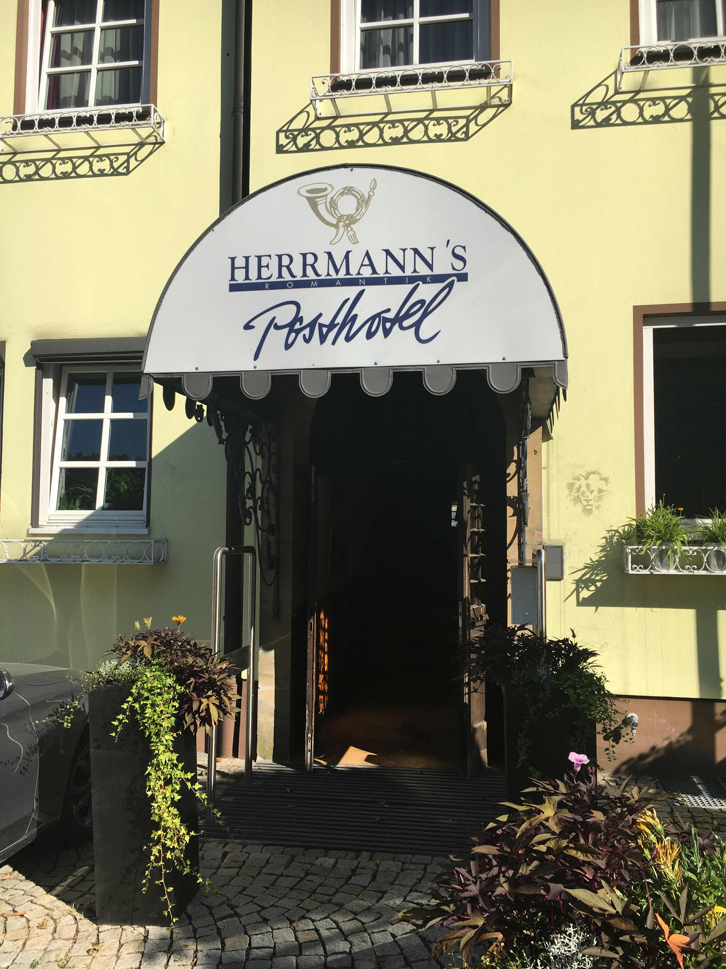 Hotel entrance before — semicircular awning, script signage