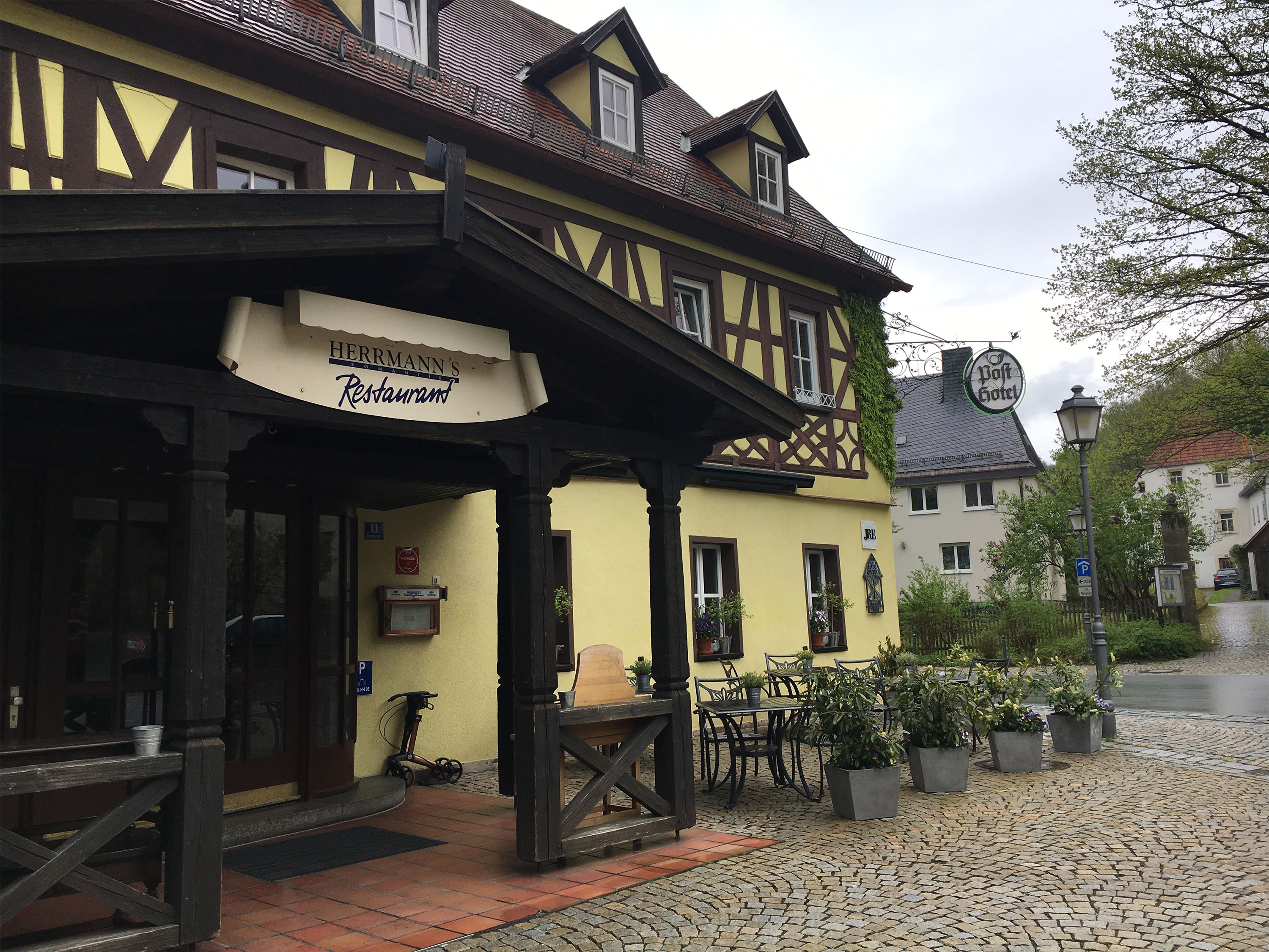 Restaurant entrance before — yellow timber frame, script signage
