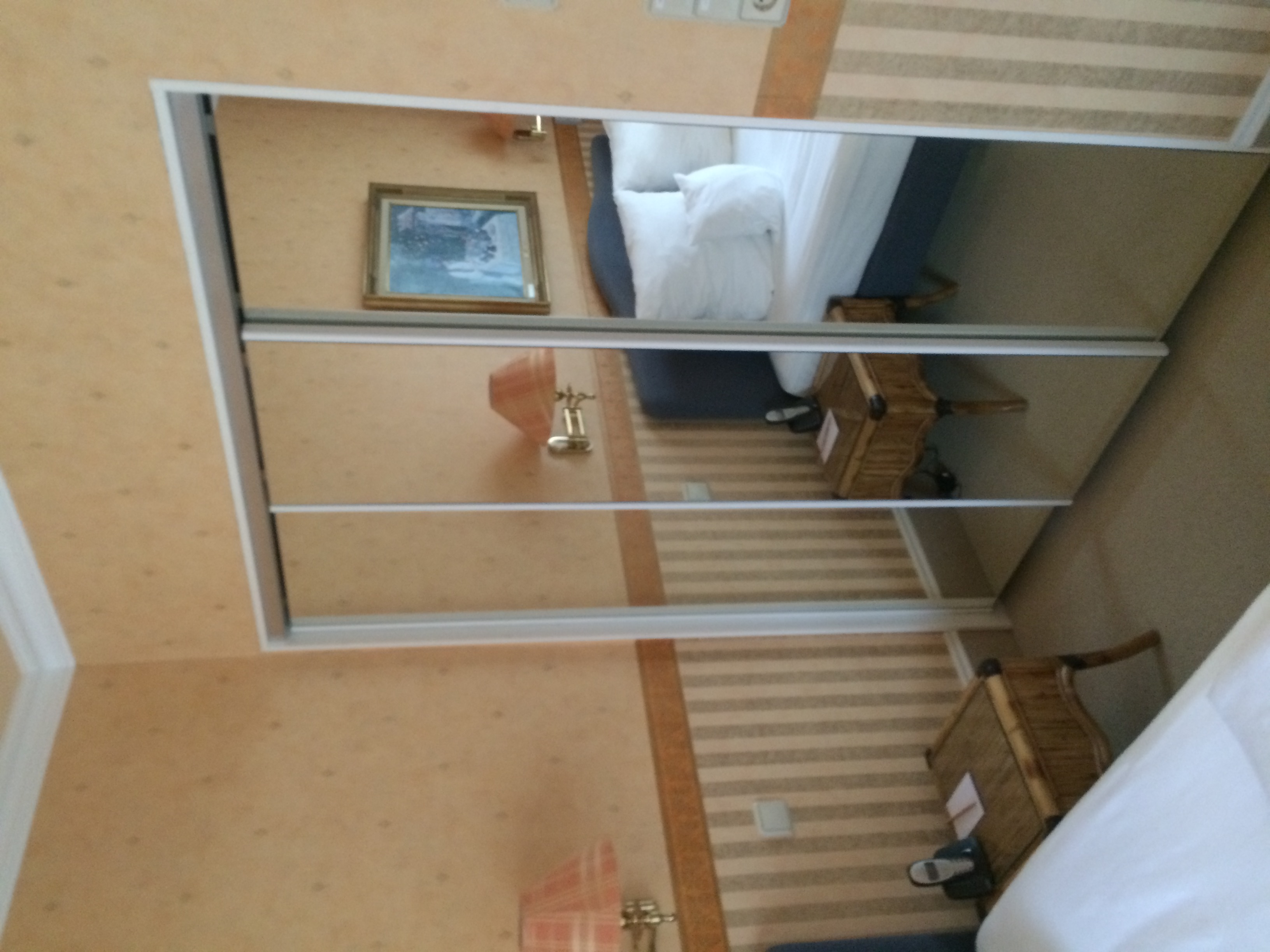 Hotel room before — peach wallpaper, mirrored wardrobe