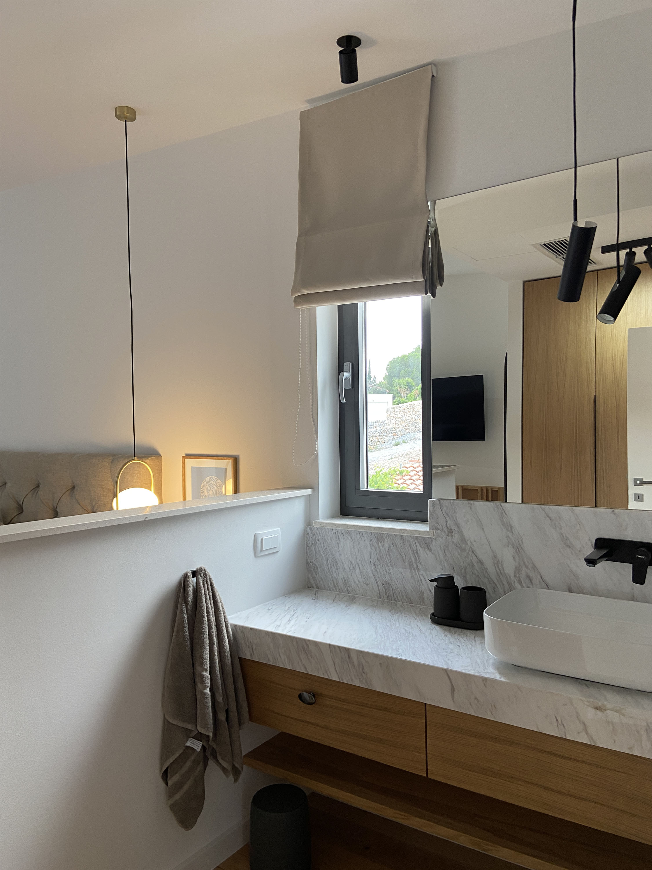 Bathroom — marble countertop, pendant light, warm evening light