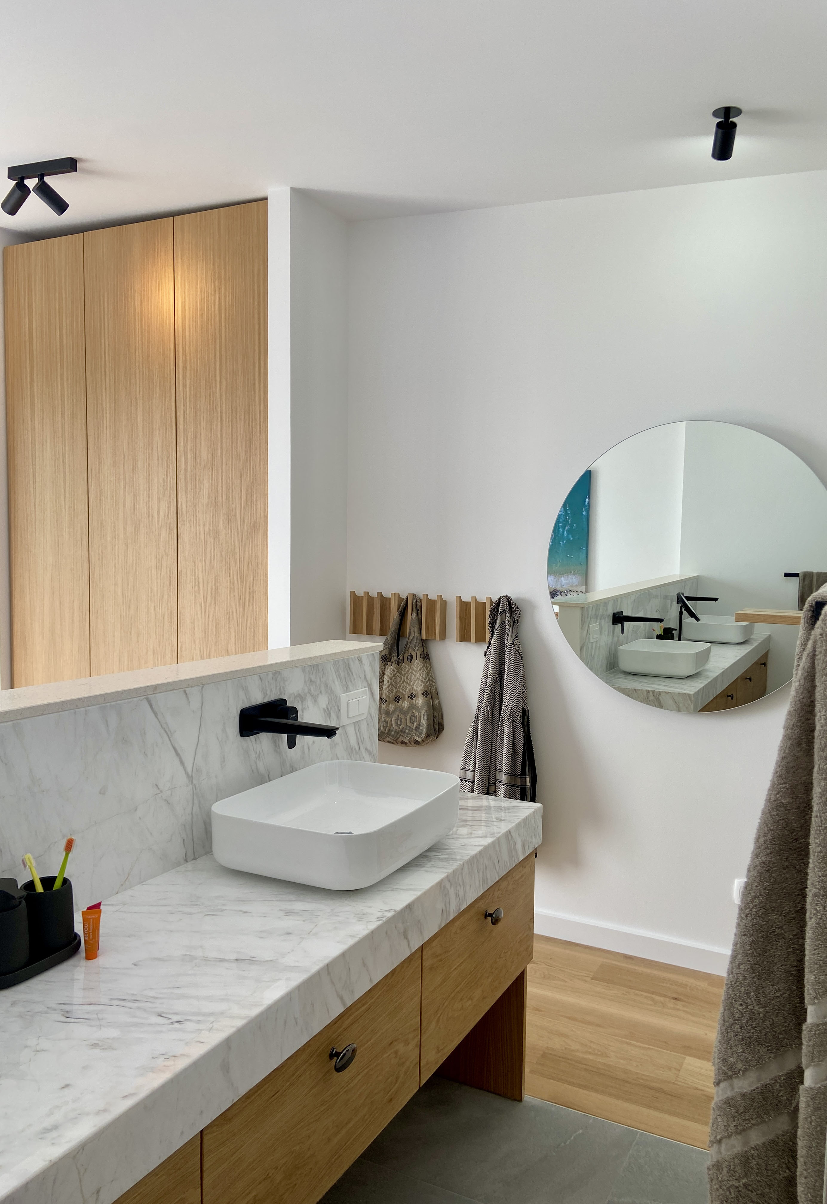 Bathroom — marble vanity, black fixtures, terrace and sea beyond